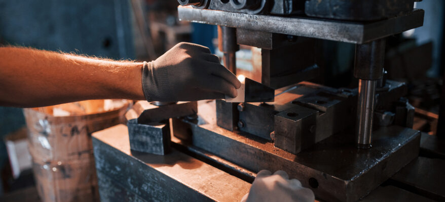 A color photograph of man's hands works with metal. Industrial conception.
